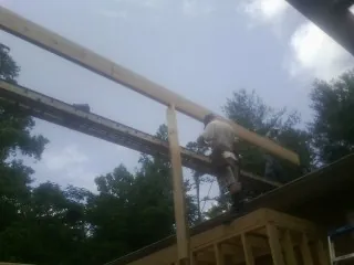 Carpenter setting a ridge beam over a new addition frame — Ice Dam Removal by Roofing Brothers in Lindstrom