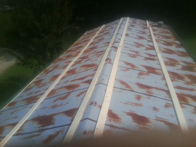 Rusted metal roof panels with new wood purlins before replacement — Storm Damage Roof Repair in Lindstrom by Roofing Brothers